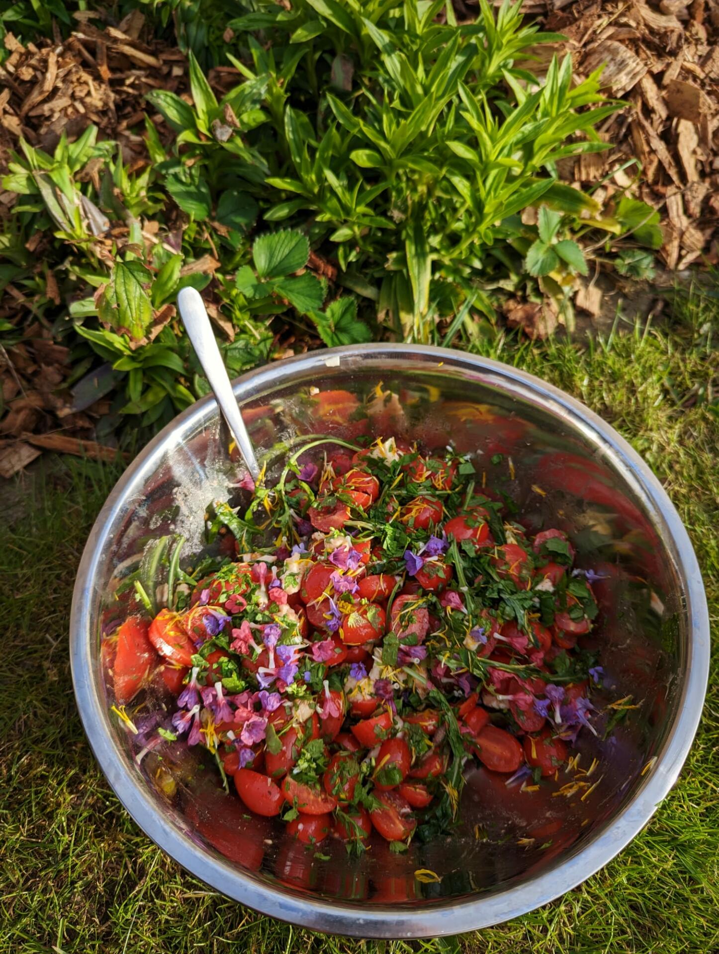 Ein Tomatensalat mit Wildblüten auf einer grünen Wiese