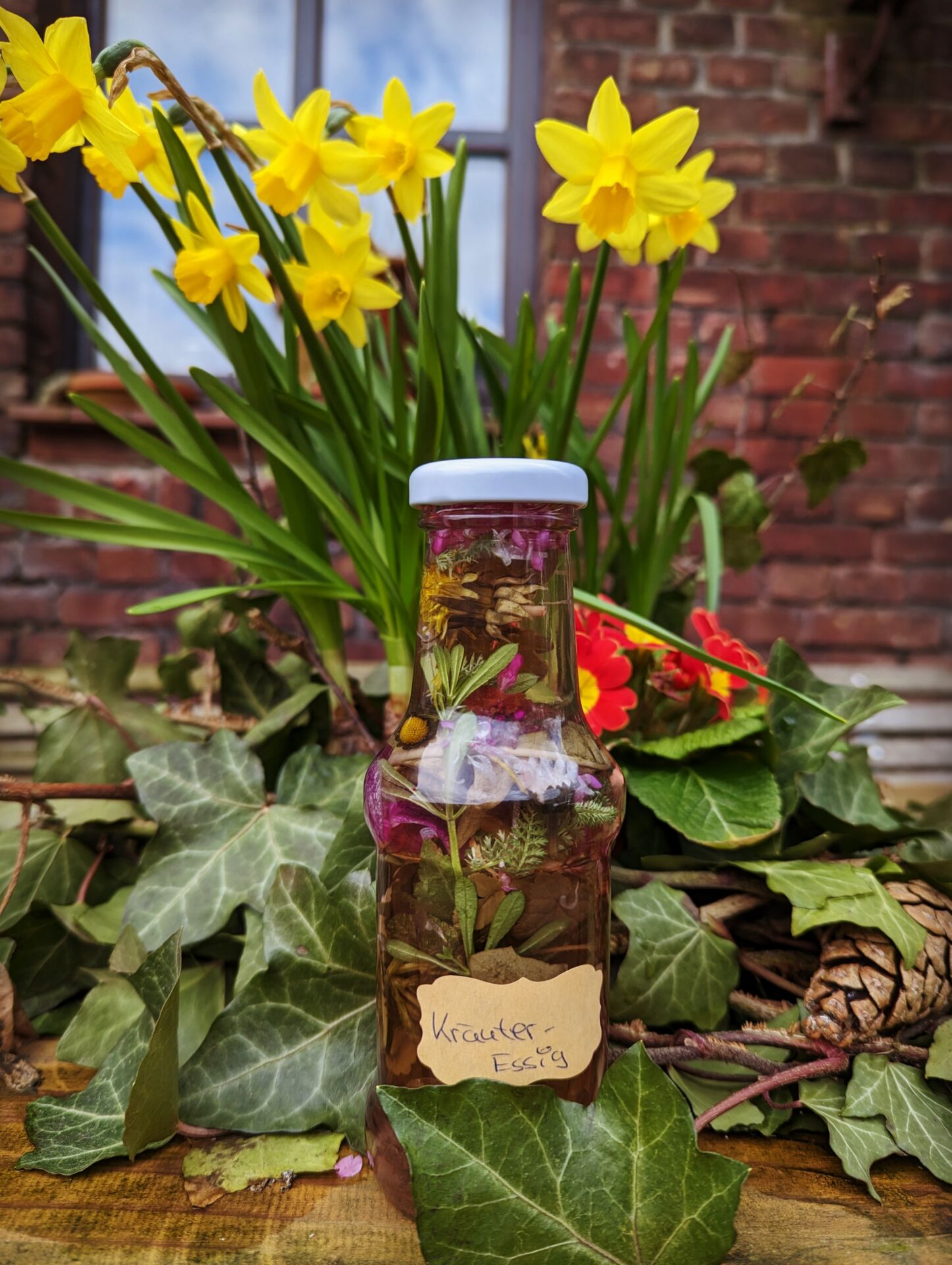 Kräuteressig vor Blüten